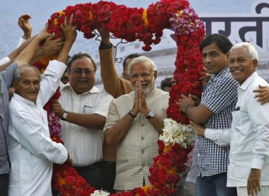 Hindu nationalist Narendra Modi, the prime ministerial candidate for India\'s main opposition BJP, gestures as he receives a garland from his supporters during a public meeting in Vadodara, in the western Indian state of Gujarat, May 16, 2014.